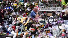 Un hombre, en el puente Black Sabbath, en Broad Street, en Birmingham, donde los seguidores dejan flores y recuerdos en memoria de Ozzy Osbourne.