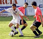 �lex G�mez trata de llevarse la pelota ante dos rivales.