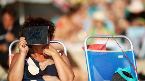 Una mujer durante el eclipse en la playa de Doni�os.
