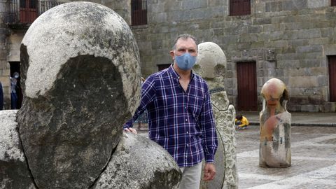 El escultor Francisco Pazos posa en la plaza de Fefiñáns con una de sus piezas