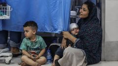 Una mujer palestina coge en brazos a su hijo herido en el Hospital Shifa.