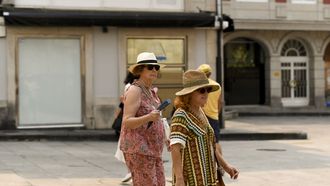 Transentes ataviadas con gorros, ropa veraniega y gafas de sol para protegerse del calor en Lugo.