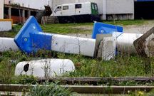 Caravana junto a la Sala Bah�a, y duchas y otro material esparcido por un terreno municipal.