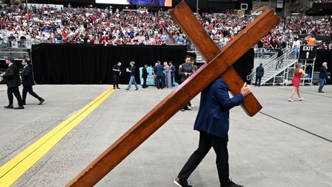 Una persona con un crucifijo en el homenaje a Charlie Kirk