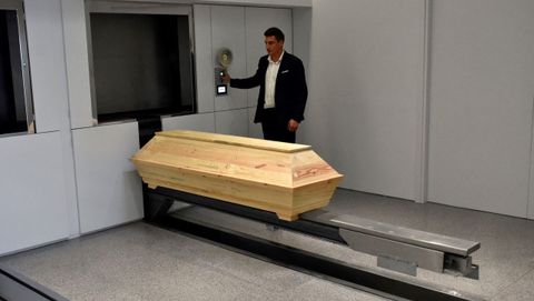 Un operario prepara un atad poco antes de entrar en la incineradora del primer crematorio inaugurado en Grecia, ubicado en Atenas
