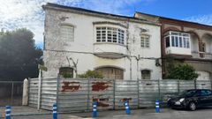 El edificio nmero 4 (blanco), en estado ruinoso, con la valla que invade la acera(colocada por Portos en septiembre de 2018)