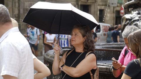 Turistas protegiéndose del sol con paraguas en Santiago