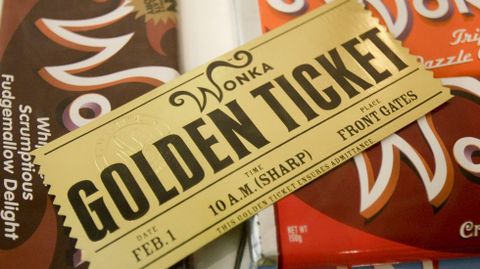 El billete dorado que le permitió a Charlie el acceso a la fábrica de chocolate de Willy Wonka, sobre tabletas de chocolate de la misma marca