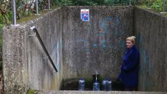 Una de las vecinas afectadas rellenando las garrafas de agua en la fuente