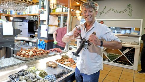 Fernando Nogueira, gerente del establecimiento situado en el centro de la ciudad, muestra alguno de los mariscos del d�a que se ofrecen en el local, todo un cl�sico vigu�s, para comer y para cenar.