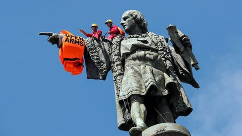 Dos escaladores de la organizacin Proactiva Open Arms, han colocado esta maana un chaleco salvavidas gigante en la estatua de Cristbal Coln en Barcelona