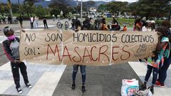 Jóvenes sostienen una pancarta de protesta durante una manifestación contra las masacres este viernes en Bogotá (Colombia)