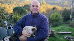 Arjen Jaarsen, con su gato, en la finca de A Lama donde vive en una caravana