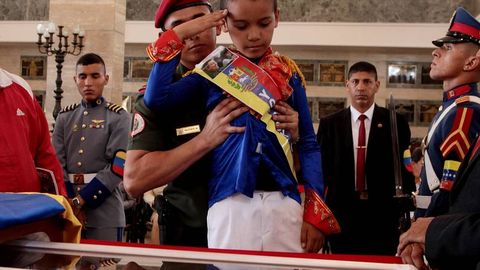 Un niño disfrazado de Bolívar presenta sus respetos a Chávez