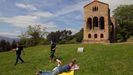 Varias personas toman el sol este domingo ante el monumento prerromnico asturiano de Santa Mara del Naranco en Oviedo.