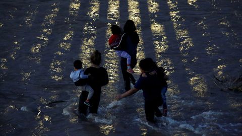 Una familia de migrantes cruza las aguas del r�o Bravo para alcanzar la frontera de Estados Unidos