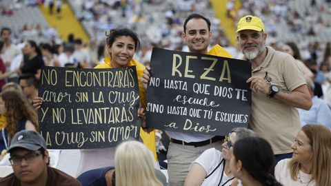 Varias personas esperan a que empiece una vigilia de 40.000 personas del papa Le�n XIV en el Estadio Ol�mpico de Barcelona.