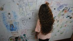 Una nia escribe en un muro, en una imagen de archivo