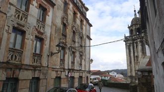 Una de las fachadas de la casa Roberes, con la iglesia de Santiago al fondo