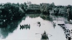 Foto hist�rica de barcas por el Cabe con el viejo puente de hierro al fondo