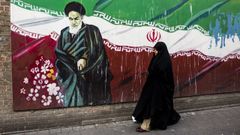 Una mujer pasea frente a un mural del ayatol� Jomeini en Teher�n.
