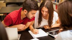 Grupo de estudiantes estudiando juntos en la biblioteca.
