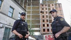 Dos de los tres polic�as que le salvaron la vida a un joven en lo alto de O Gara��n este jueves, frente al edificio.