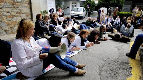 Profesionales sanitarios, acostados en el patio del Abente y Lago para protestar contra el cierre de camas en el Chuac