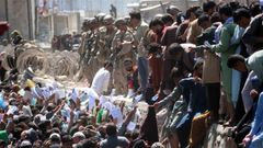 Decenas de afganos muestran sus documentos para tratar de acceder al aeropuerto de Kabul. 