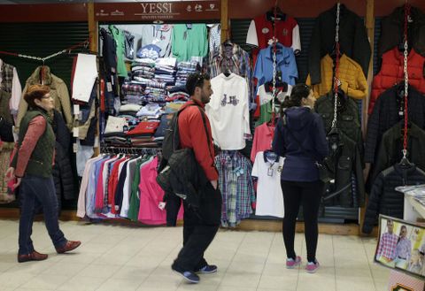 Una vendedora del mercado de A Pedra, junto a dos clientes ayer que miran los puestos. 