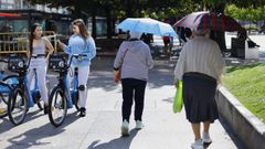 Dos se�oras utilizan paraguas para protegerse del sol.