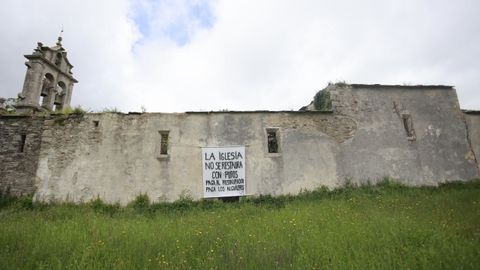 Vista de un muro lateral de la iglesia de Carao, con una pancarta relativa a la stiuacin.