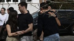 Varias personas durante el minuto de silencio en homenaje a los estudiantes fallecidos en el derrumbe de una pasarela costera en El Bocal de Santander