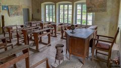 Un aula de una escuela de la Asturias rural cerrada con los pupitres intactos.