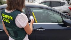 Una agente de la Guardia Civil busca huellas dactilares en un veh�culo