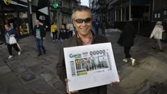 Manuel Mart�nez Pan, delegado en Galicia de la ONCE, en la calle Real posando con el cup�n dedicado a la c�ntrica v�a de A Coru�a.