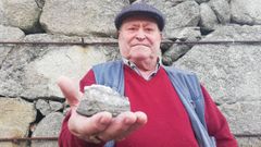 Manuel G�mez, con una piedra del wolframio en la mano, en su vivienda en una aldea de Lobios