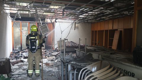 Interior de la vivienda tras el incendio, con un bombero del SPEIS. 