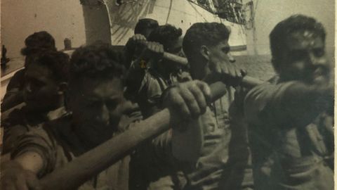 Marineros remando con el Galatea de fondo
