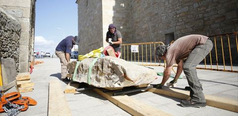 Los especialistas de Terra-Arqueos, con el trozo de la roca desgajado de la Pedra de Abalar, ya junto a la ermita de A Barca. 