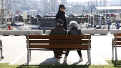 Una pareja descansando al sol en la zona de la Marina de A Corua.