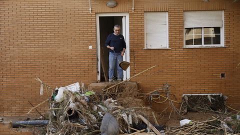  Un hombre limpia su vivienda de los daos causados por las inundaciones en la localidad de Paiporta