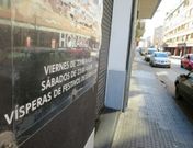 Cartel con los horarios de apertura en el exterior de un pub de la calle de copas. 