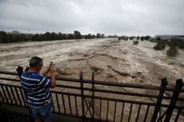 Un hombre toma una foto en un puente del r�o Var, desbordado, en los alrededores de Niza (Francia) 