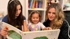 Luj�n junto a sus hijas leyendo un libro en ingl�s