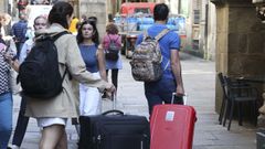 Dos turistas, caminando con sus maletas por el casco hist�rico de Santiago, en una imagen de archivo. 