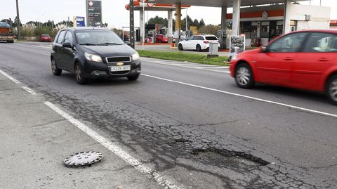 Peligrosa rotura del asfalto en la carretera de Catabois, frente a la gasolinera, con un tapacubos en el arc�n.