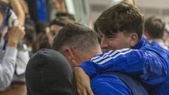 Dos jvenes aficionados del Oviedo se abrazan a Masca en el aparcamiento del Tartiere