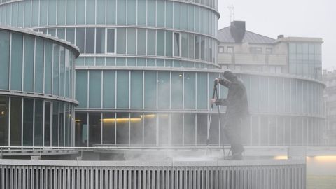 Un operario limpia la fachada del ayuntamiento de Laln