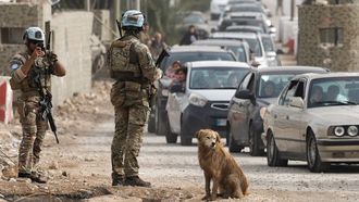 Los compa�eros del soldado abatido en el sur de L�bano vigilan el trasiego de veh�culos en la zona de Qasmiyeh, pocas horas despu�s del ataque